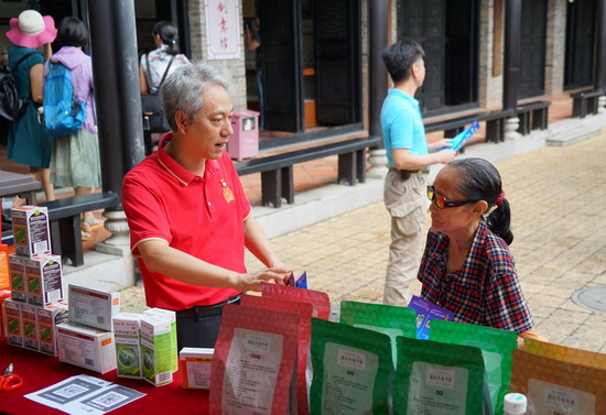 潘高寿传统中药文化传承人卢其福向市民仔细讲解2-1.jpg
