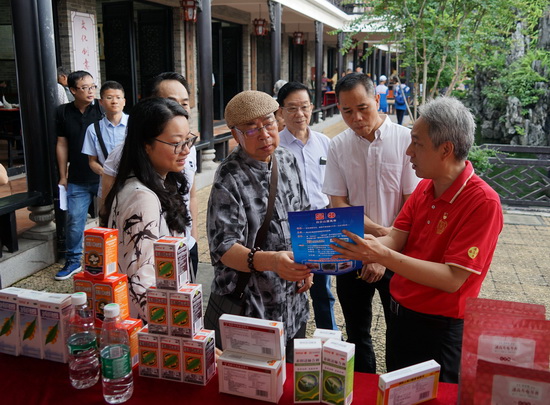 潘高寿传统中药文化传承人卢其福向市民仔细讲解3-1.jpg